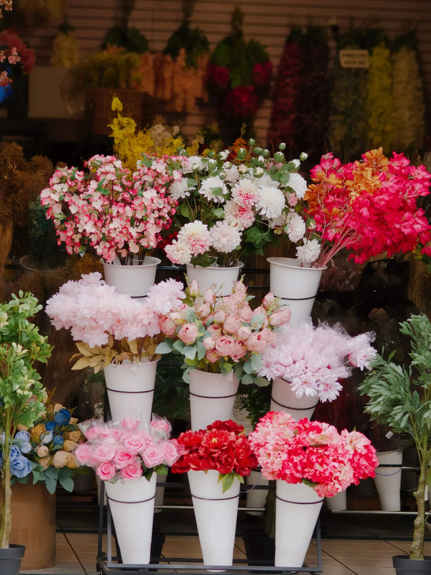 店先の白いバケツに並ぶ切り花
